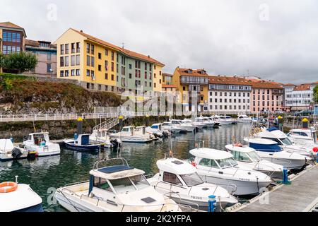 Wunderschöner Yachthafen von Llanes City, im Norden Spaniens - Asturien. Blick auf die angedockten Boote. Im Hintergrund die Stadt Llanes mit bunten Gebäuden und Schönheit Stockfoto