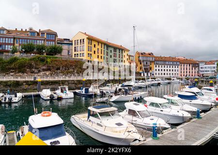 Wunderschöner Yachthafen von Llanes City, im Norden Spaniens - Asturien. Blick auf die angedockten Boote. Im Hintergrund die Stadt Llanes mit bunten Gebäuden und Schönheit Stockfoto