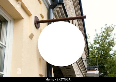 Modell. Weiße leere runde Kreischablone auf leerer Gebäudewand. Beschilderung von Geschäft, Geschäft, Büro im Freien Stockfoto