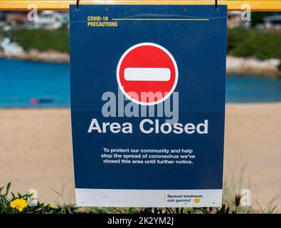 Eine Nahaufnahme eines Strandschilds mit der Aufschrift „Gebiet geschlossen“, das auf die Vorsichtsmaßnahmen des Coronavirus gerichtet ist. Stockfoto