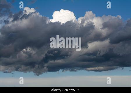 Graue dunkle Wolken am blauen Himmel Stockfoto