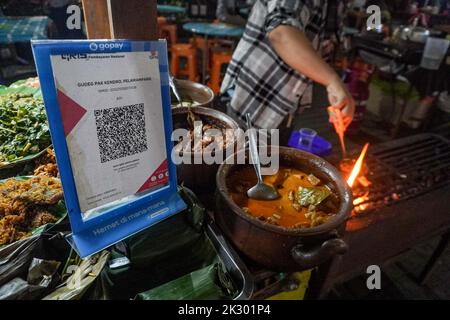 South Jakarta, Jakarta, Indonesien. 23. September 2022. Ein Straßenhändler, der ein QR-Code-Zahlungssystem bereitstellt, bedient einen Käufer. Das Quick Response (QR) Code-Zahlungssystem wird in 5 ASEAN-Länder integriert: Indonesien, Malaysia, Thailand, Singapur, Und die Philippinen, deren Realisierungsziel der 2022. November ist, wie PERRY WARJIYO, der Gouverneur der Bank Indonesia, am 2022. Juli. (Bild: © Dicky Bisinglasi/ZUMA Press Wire) Bild: ZUMA Press, Inc./Alamy Live News Stockfoto