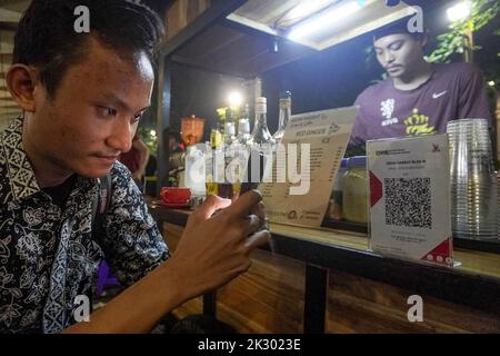 South Jakarta, Jakarta, Indonesien. 23. September 2022. Ein Käufer scannt das QR-Code-Zahlungssystem bei einem Straßenhändler. Â das Quick Response (QR)-Code-Zahlungssystem wird in 5 ASEAN-Länder integriert: Indonesien, Malaysia, Thailand, Singapur, Und die Philippinen, deren Realisierungsziel der 2022. November ist, wie PERRY WARJIYO, der Gouverneur der Bank Indonesia, am 2022. Juli. (Bild: © Dicky Bisinglasi/ZUMA Press Wire) Bild: ZUMA Press, Inc./Alamy Live News Stockfoto