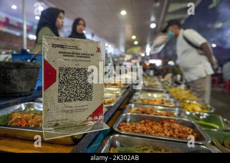 South Jakarta, Jakarta, Indonesien. 23. September 2022. Ein Straßenhändler, der ein QR-Code-Zahlungssystem bereitstellt, bedient einen Käufer. Das Quick Response (QR) Code-Zahlungssystem wird in 5 ASEAN-Länder integriert: Indonesien, Malaysia, Thailand, Singapur, Und die Philippinen, deren Realisierungsziel der 2022. November ist, wie PERRY WARJIYO, der Gouverneur der Bank Indonesia, am 2022. Juli. (Bild: © Dicky Bisinglasi/ZUMA Press Wire) Bild: ZUMA Press, Inc./Alamy Live News Stockfoto