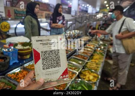 South Jakarta, Jakarta, Indonesien. 23. September 2022. Ein Straßenhändler, der ein QR-Code-Zahlungssystem bereitstellt, bedient einen Käufer. Das Quick Response (QR) Code-Zahlungssystem wird in 5 ASEAN-Länder integriert: Indonesien, Malaysia, Thailand, Singapur, Und die Philippinen, deren Realisierungsziel der 2022. November ist, wie PERRY WARJIYO, der Gouverneur der Bank Indonesia, am 2022. Juli. (Bild: © Dicky Bisinglasi/ZUMA Press Wire) Bild: ZUMA Press, Inc./Alamy Live News Stockfoto