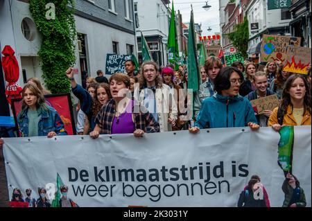 Demonstranten werden mit einem großen Banner gesehen, auf dem steht, dass der Klimastreik während der Demonstration erneut begonnen hat. Studenten und junge Menschen aus allen Teilen des Landes versammelten sich in der niederländischen Stadt Arnhem, um Maßnahmen für die Forderungen indigener, schwarzer und anderer marginalisierter Gemeinschaften zu fordern, ihr Land neu anzueignen. Die Klima-Jugendorganisation #FridaysForFuture hat diesen märz organisiert, um weiterhin eine bessere Klimapolitik zu fordern und die Zerstörung des Landes von MAPA (am stärksten betroffene Völker und Gebiete) zu stoppen. (Foto von Ana Fernandez/SOPA Images/Sipa USA) Stockfoto