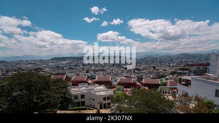 Panoramablick auf den nördlichen zentralen Teil der Stadt Quito voller moderner Gebäude mit dem Cumbaya-Tal im Hintergrund während eines sonnigen Mornins Stockfoto
