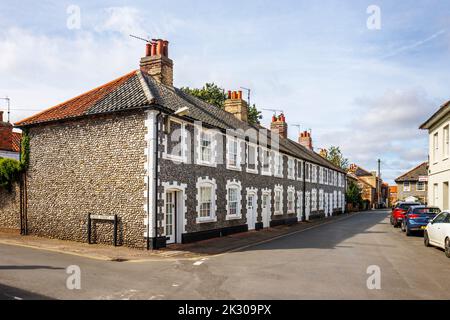 Terrasse von Häusern im lokalen Architekturstil mit Steinmauern in holt, einer kleinen historischen georgischen Marktstadt im Norden Norfolks, England Stockfoto