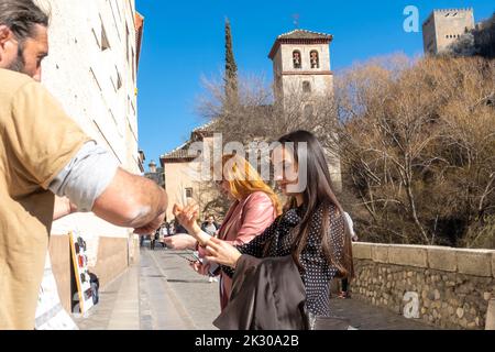 Fe,ALE Touristen kaufen Schmuck Souvenirs von der Straße Verkäufer in Puente de Espinosa, Albaicín, Granada Stadtzentrum, Andalusien, Spanien Stockfoto