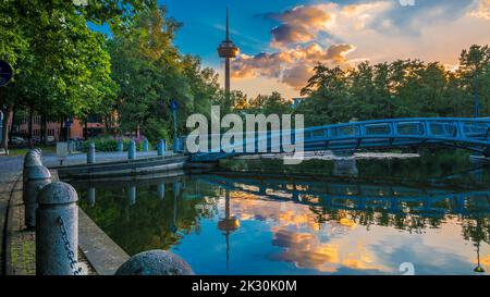 Deutschland, Nordrhein-Westfalen, Köln, MediaPark Seebrücke bei Dämmerung mit Colonius-Turm im fernen Hintergrund Stockfoto