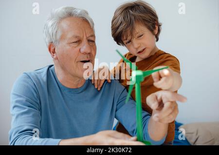 Großvater und Enkel analysieren zu Hause das Windenergieanlagenmodell Stockfoto