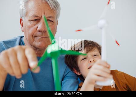 Großvater und Enkel analysieren Windenergieanlagenmodelle zu Hause Stockfoto