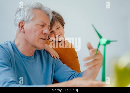 Großvater und Enkel analysieren zu Hause das Windenergieanlagenmodell Stockfoto