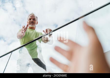 Reifer Mann, der nach der Hand eines Freundes greift Stockfoto