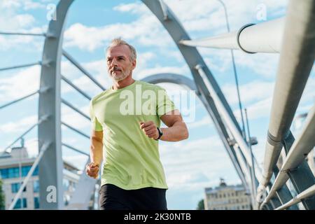 Mann, der in der Stadt auf einer Hängebrücke läuft Stockfoto