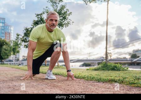 Reifer Mann, der sich auf den Lauf im Park vorbereitet Stockfoto