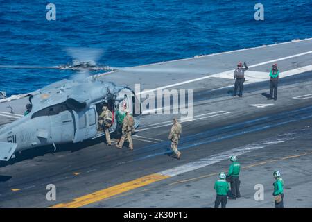 220921-N-UF592-1027 PHILIPPINISCHES MEER (SEPT 21, 2022) Mitglieder der mobilen Einheit für die Entsorgung explosiver Ordnanzen (EODMU) 5, die dem Kommandanten, der Task Force (CTF) 70, an Bord eines MH-60s Seahawk, an den Golden Falcons of Helicopter Sea Combat Squadron (HSC) 12 angeschlossen ist, Für eine HRST-Übung (HRST) auf dem Flugdeck des einzigen vorwärts eingesetzten Flugzeugträgers der US-Marine, USS Ronald Reagan (CVN 76), in der philippinischen See, September 21. Ronald Reagan, das Flaggschiff der Carrier Strike Group 5, stellt eine kampfbereite Truppe bereit, die die Vereinigten Staaten schützt und verteidigt, und unterstützt eine Stockfoto