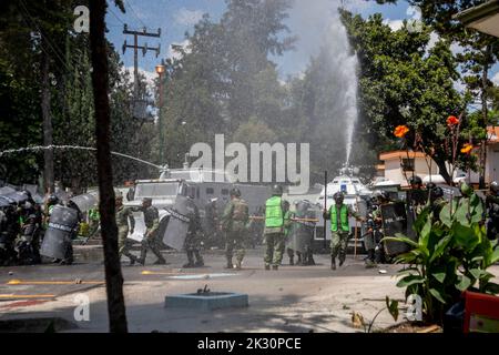 Mexiko Stadt, Mexiko. 23. September 2022. Polizei und Soldaten setzen Wasserwerfer gegen Demonstranten ein, die gegen das Verschwinden von 43 Studenten der Escuela Normal Rural 'Raúl Isidro Burgos', einer High School in Ayotzinap, protestieren. In wenigen Tagen wird es der achte Jahrestag der Entführung von Studenten in Mexiko sein. Demonstranten protestieren gegen die Polizei. Quelle: Jair Cabrera Torres/dpa/Alamy Live News Stockfoto