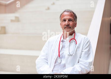 Selbstbewusster Oberarzt mit Stethoskop im Krankenhaus Stockfoto