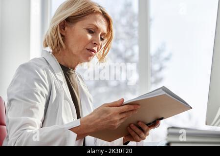 Arzt untersucht medizinischen Bericht in der Klinik Stockfoto