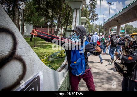 Mexiko Stadt, Mexiko. 23. September 2022. Demonstranten, die gegen das Verschwinden von 43 Studenten der Escuela Normal Rural 'Raúl Isidro Burgos', einer High School in Ayotzinap, protestieren, werfen vor einem Militärstützpunkt Steine auf Soldaten. In wenigen Tagen wird es der achte Jahrestag der Entführung von Studenten in Mexiko sein. Demonstranten protestieren gegen die Polizei. Quelle: Jair Cabrera Torres/dpa/Alamy Live News Stockfoto