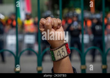 Mexiko Stadt, Mexiko. 23. September 2022. Eine Mutter protestiert mit erhobener Faust und einem Armband mit der Nummer 43. Demonstranten, die gegen das Verschwinden von 43 Studenten der Escuela Normal Rural 'Raúl Isidro Burgos', einer High School in Ayotzinap, protestierten, haben sich vor dem Militärlager versammelt. In wenigen Tagen wird es der achte Jahrestag der Entführung von Studenten in Mexiko sein. Quelle: Jair Cabrera Torres/dpa/Alamy Live News Stockfoto