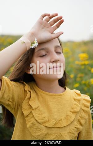 Mädchen mit Kamillen auf der Hand mit Verband auf dem Feld befestigt Stockfoto