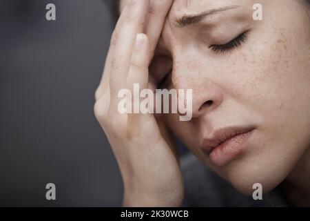 Traurige Frau, die an Kopfschmerzen leidet Stockfoto