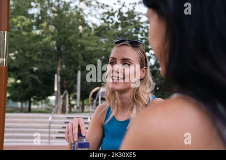 Glückliche junge Frau im Gespräch mit einem Freund Stockfoto