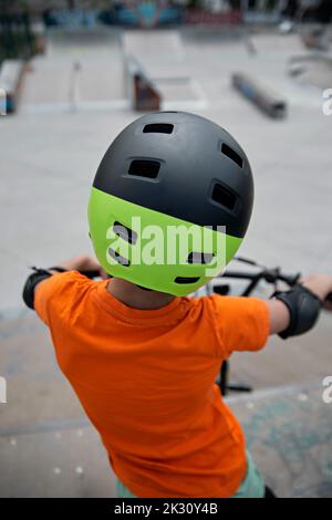 Boy mit Helm auf BMX-Bike im Skatepark Stockfoto