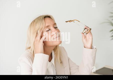 Müde Geschäftsfrau mit geschlossenen Augen im Büro Stockfoto