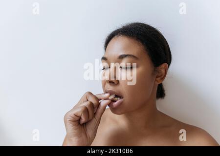 Junge Frau, die eine Pille Stockfoto