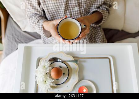 Frau beim Frühstück im Bett sitzend Stockfoto
