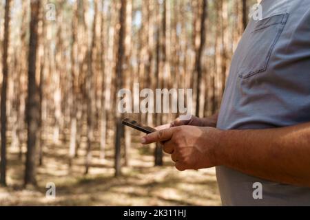 Mann mit Smartphone im Wald Stockfoto