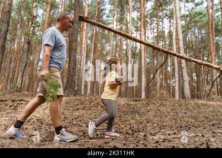 Reifer Mann mit Mädchen Wandern im Wald Stockfoto