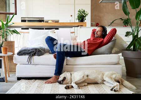 Geschäftsmann und Hund entspannen im Wohnzimmer Stockfoto