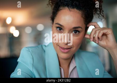 Lächelnde, selbstbewusste, reife Geschäftsfrau am Arbeitsplatz Stockfoto