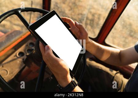 Landwirt mit Tablet-PC im Traktor Stockfoto
