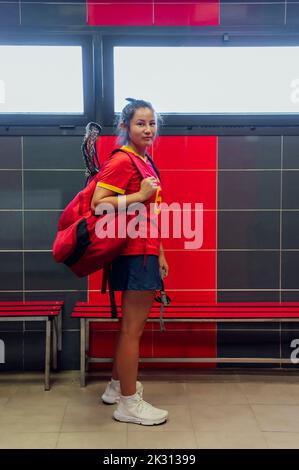 Junger Athlet mit Rucksack im Umkleideraum Stockfoto