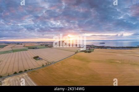 Großbritannien, Schottland, North Berwick, Luftaufnahme der Felder vor der Küstenstadt bei bewölktem Sonnenuntergang im Sommer Stockfoto