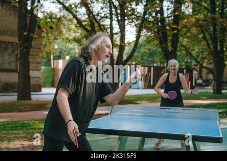 Ein Paar spielt Tischtennis im Park Stockfoto