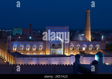 Die alte Madrasa von Muhammad Rahim Khan im Hintergrund in der urbanen Nachtlandschaft. Ichan-Kala, Hiva. Usbekistan. Stockfoto