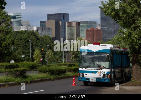 Ein japanischer Polizeibus mit Wolkenkratzern auf der Straße. Tokio, Japan. Stockfoto