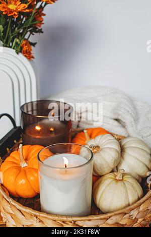 Gemütliche Herbststill-Life-Komposition mit dekorativen Kürbissen und Kerzen. Einrichtung im Herbst. Stockfoto