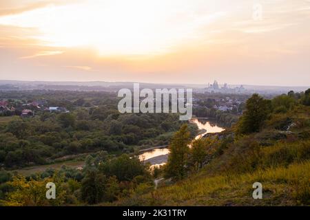 Panoramablick auf die Stadt Ivano-Frankivsk. Blick auf den Berg und das Industriekraftwerk oland am Abend. Sonnenuntergang über Ivano Frankivsk Stockfoto