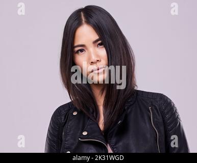 Sie macht Mode attraktiv. Eine schöne junge Frau, die in einem Studio steht. Stockfoto