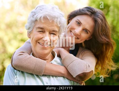 Wenn du eine Tochter hast, hast du einen Freund fürs Leben. Eine junge Frau und ihre ältere Mutter stehen draußen. Stockfoto