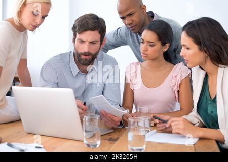 Arbeiten an Möglichkeiten zur Verbesserung des Geschäfts. Eine Gruppe von Geschäftsleuten in der Mitte einer Diskussion. Stockfoto