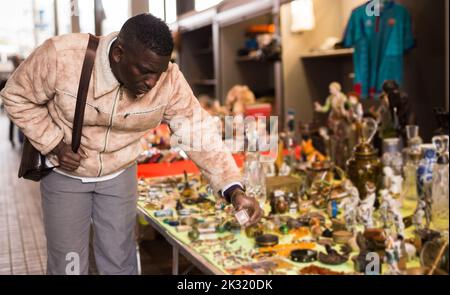 Afroamerikanischer Mann wählt Antiquitäten auf dem Flohmarkt Stockfoto