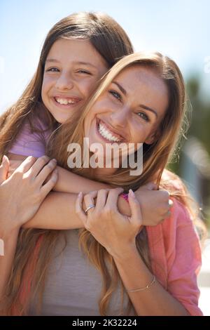 Frohe Festtage. Porträt einer liebevollen Mutter und Tochter, die im Freien zusammen stehen. Stockfoto